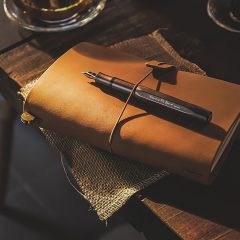 乐学好老师内容主笔林知远在书桌前对着屏幕逐条复核公开学习资源索引，台灯暖光与堆叠的教辅资料营造出安静严谨的编辑工作氛围